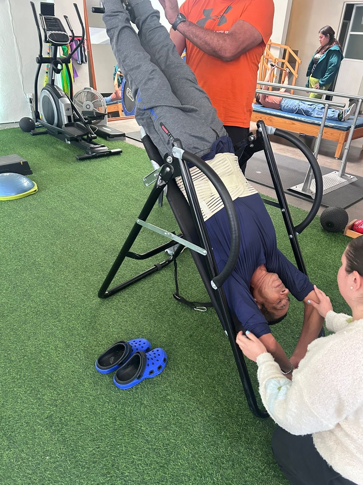 Paciente en mesa de inversión con apoyo de fisioterapeuta para tratamiento de hernia discal y dolor de espalda en Lumive Fisioterapia
