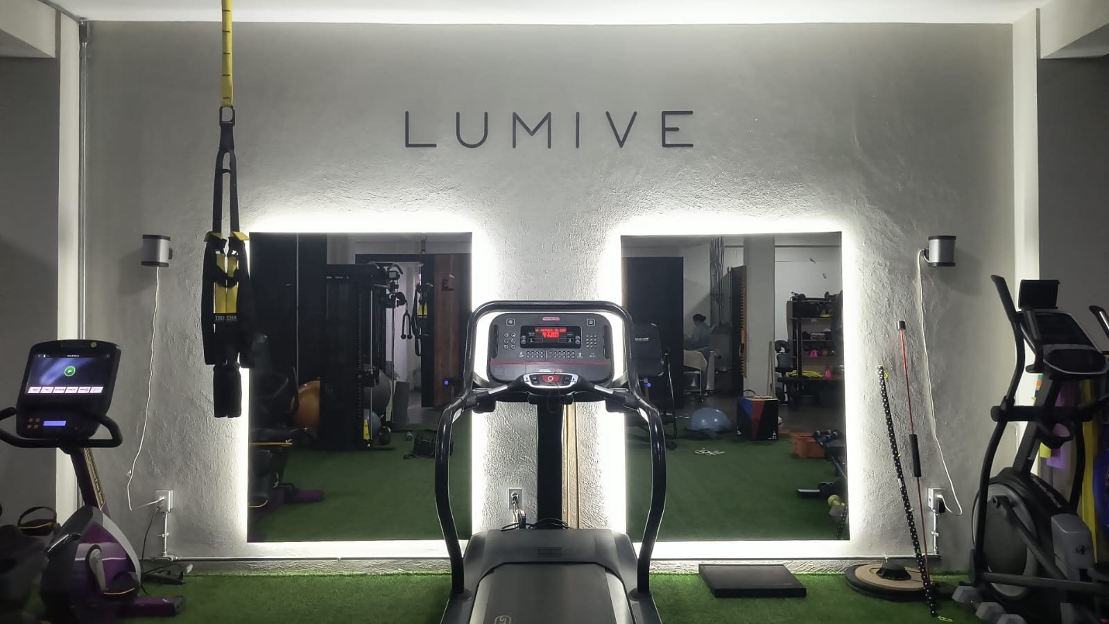 Área de ejercicio terapéutico con letrero Lumive iluminado en Lumive Fisioterapia San Juan del Río, Querétaro