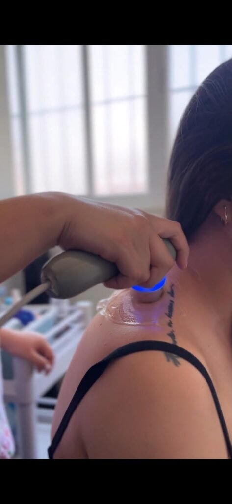 Fisioterapeuta aplica ultrasonido terapéutico en la espalda de un paciente con dolor de espalda en Lumive Fisioterapia
